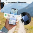 Person holds a smartphone showing a 'Wallet left behind' urgent alert, with mountains in the background and a blue wallet resting on a rock nearby.